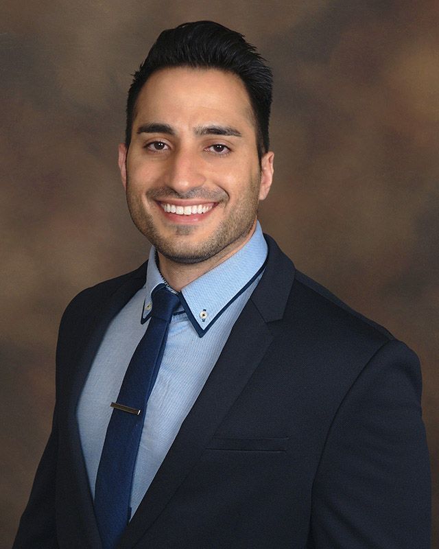 Portrait of Dr. Amir Moradian in a navy suit and tie